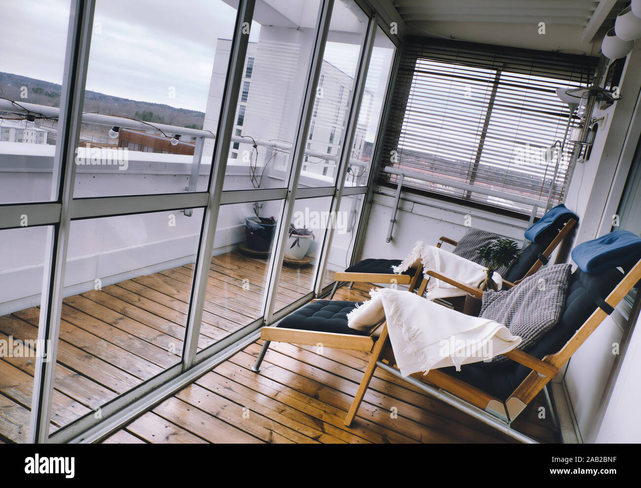 Alto edificio di lusso Appartamento terrazza coperta con porte scorrevoli di vetro e sedie reclinabili, Upplands Vasby, Stoccolma, Svezia Foto Stock