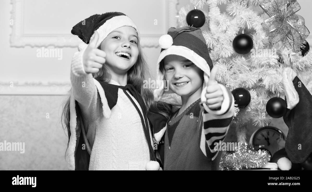 Bambini allegro festeggiare il Natale. Bambini i costumi di natale santa e ELF. Inverno concetto masquerade. I fratelli pronto per festeggiare il Natale o soddisfare il nuovo anno. Auguri di Buon Natale. Vacanza familiare di tradizione. Foto Stock