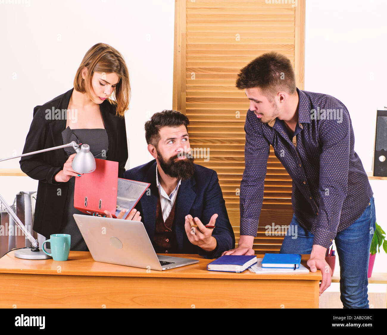 Una riunione ad hoc. I responsabili principali informale riunione d'affari. Persone che fanno la grande discussione aziendale in sala riunioni. Le persone di affari digitare Resoconto riunione sul laptop. Foto Stock