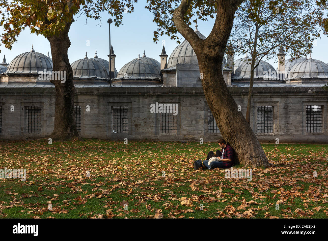 Istanbul, Turkey-Nov 15, 2019: le persone a rilassarsi sotto un albero nel giardino della Moschea Suleymaniye in Istanbul.it è una delle zone più tranquille in autunno Foto Stock