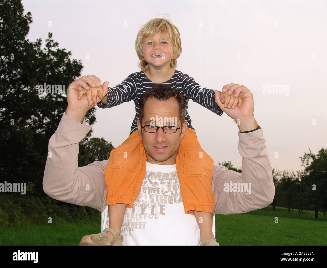 Sohn sitzt Vater auf Schulter Foto Stock