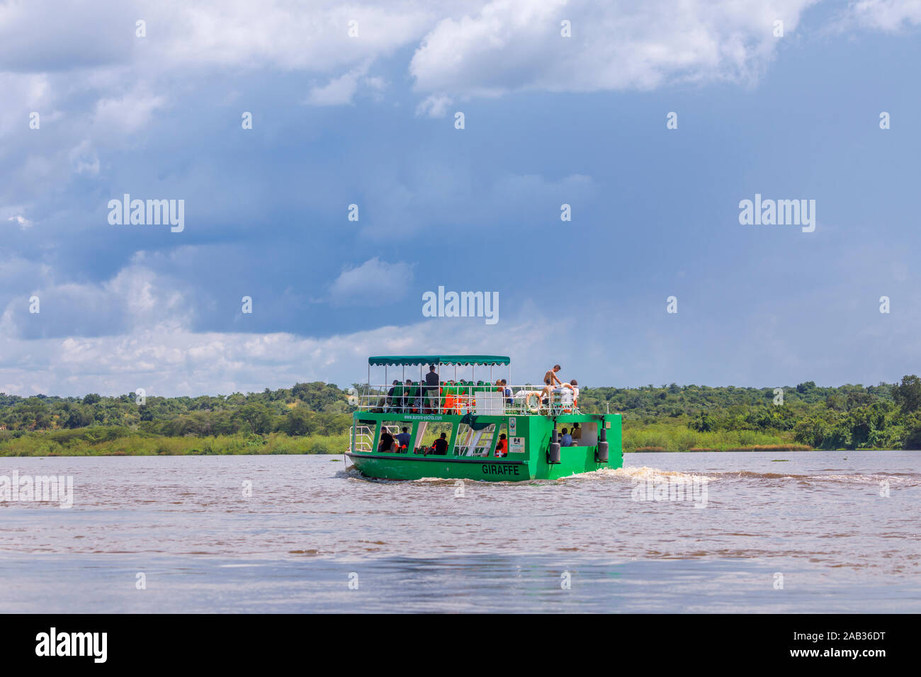 Tipico turista wildlife safari gita in barca a vela in corso sulla Victoria Nile, nord ovest dell Uganda in una giornata di sole con pioggia nuvole Foto Stock