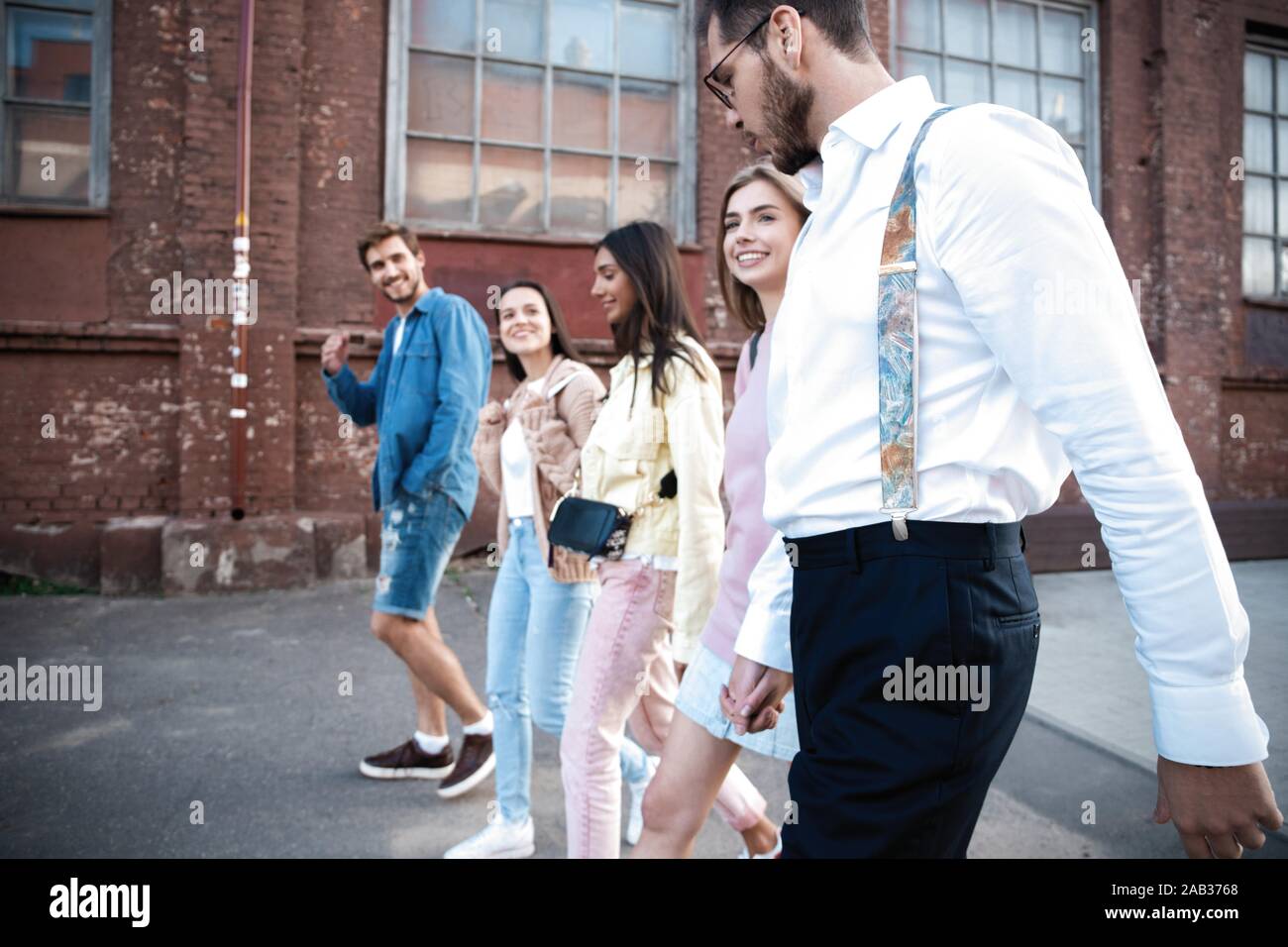 Gruppo di felice giovani amici divertendosi sulla strada di città Foto Stock