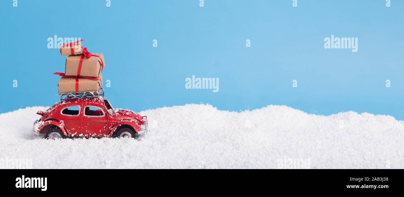 Confezioni regalo su toy vintage auto Volkswagen maggiolino oltre innevate sullo sfondo di Natale Foto Stock