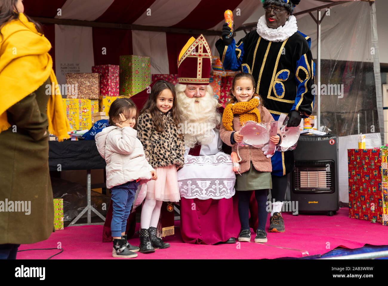 Eindhoven, Paesi Bassi, 23 novembre 2019. Sinterklaas indossa il suo costume e avente bambine accanto a lui mentre posa per la telecamera e g Foto Stock