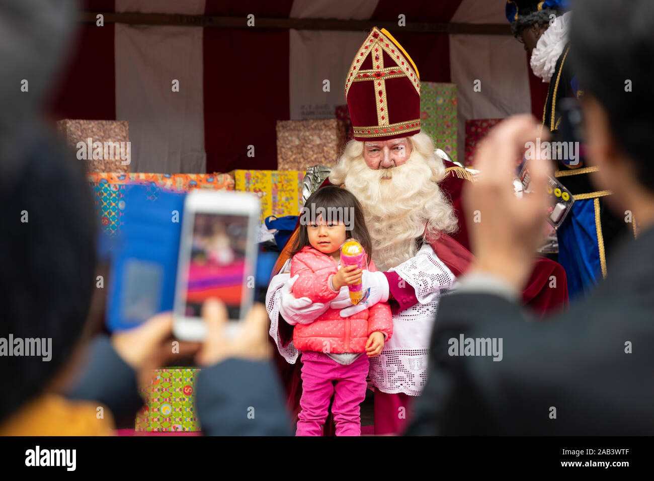 Eindhoven, Paesi Bassi, 23 novembre 2019. Sinterklaas indossa il suo costume e avente una bambina accanto a lui mentre posa per la telecamera e Foto Stock