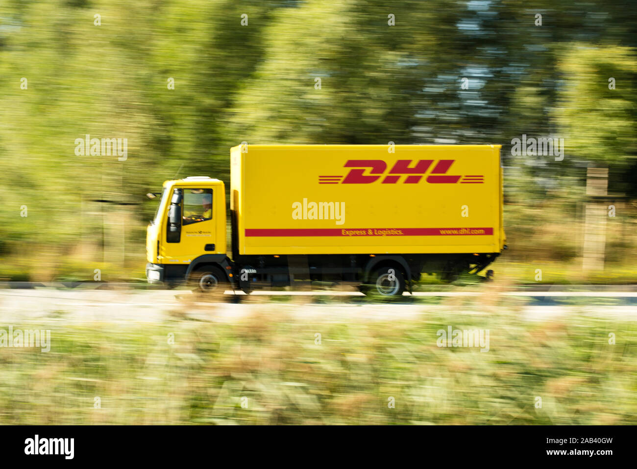 Lastkraftwagen von DHL auf dem Weg ins Logistikzentrum |DHL camion sulla strada per il centro di logistica| Foto Stock