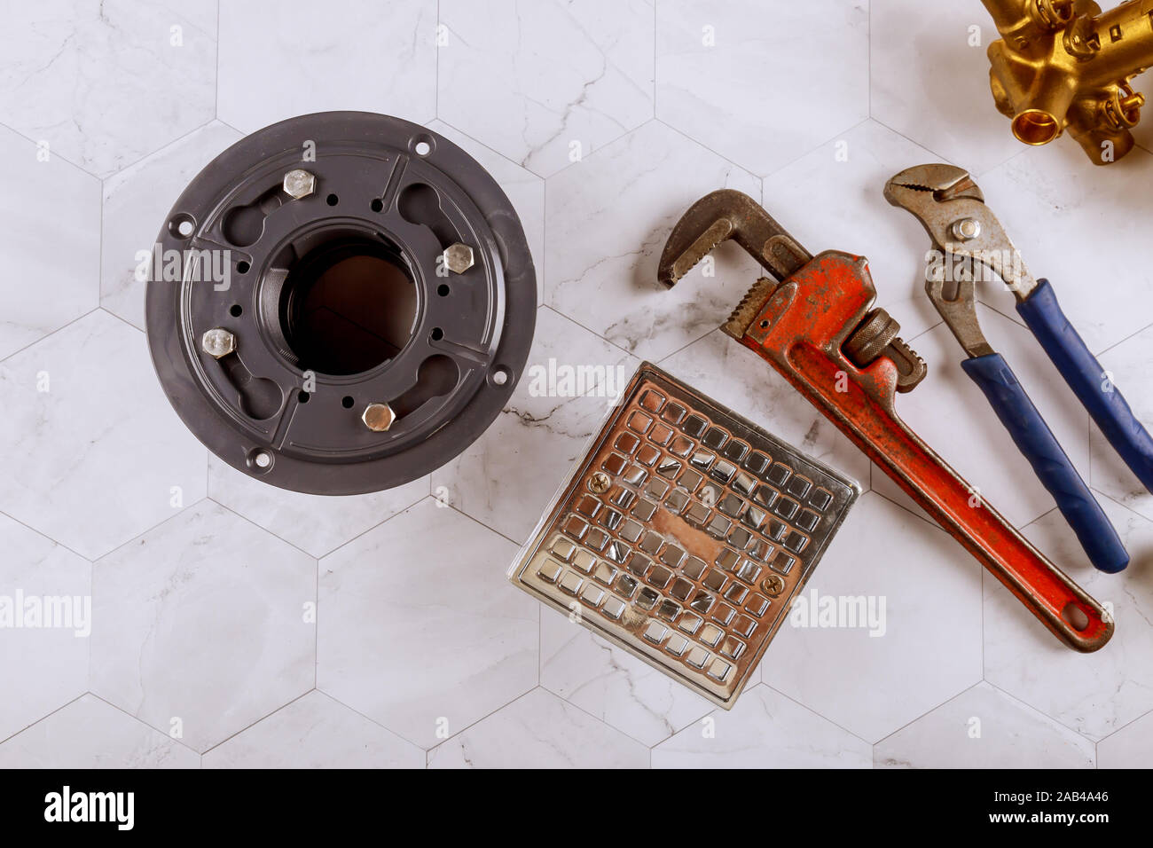 Impianti idraulici e Monkey Wrench sporco bagno in acciaio inox lo scarico della doccia era in stile moderno Foto Stock