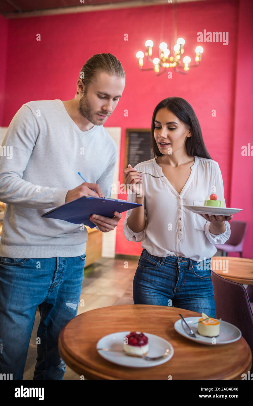 Imprenditori discutendo dessert insieme prima di lanciare il nuovo menu Foto Stock