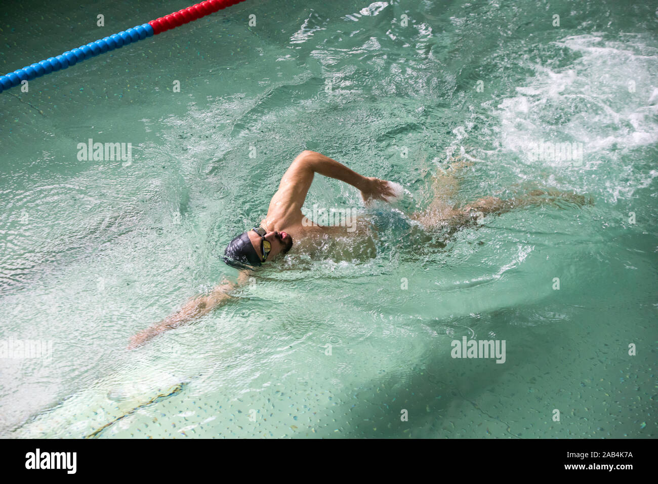 Uomo di nuoto in piscina coperta. Foto Stock