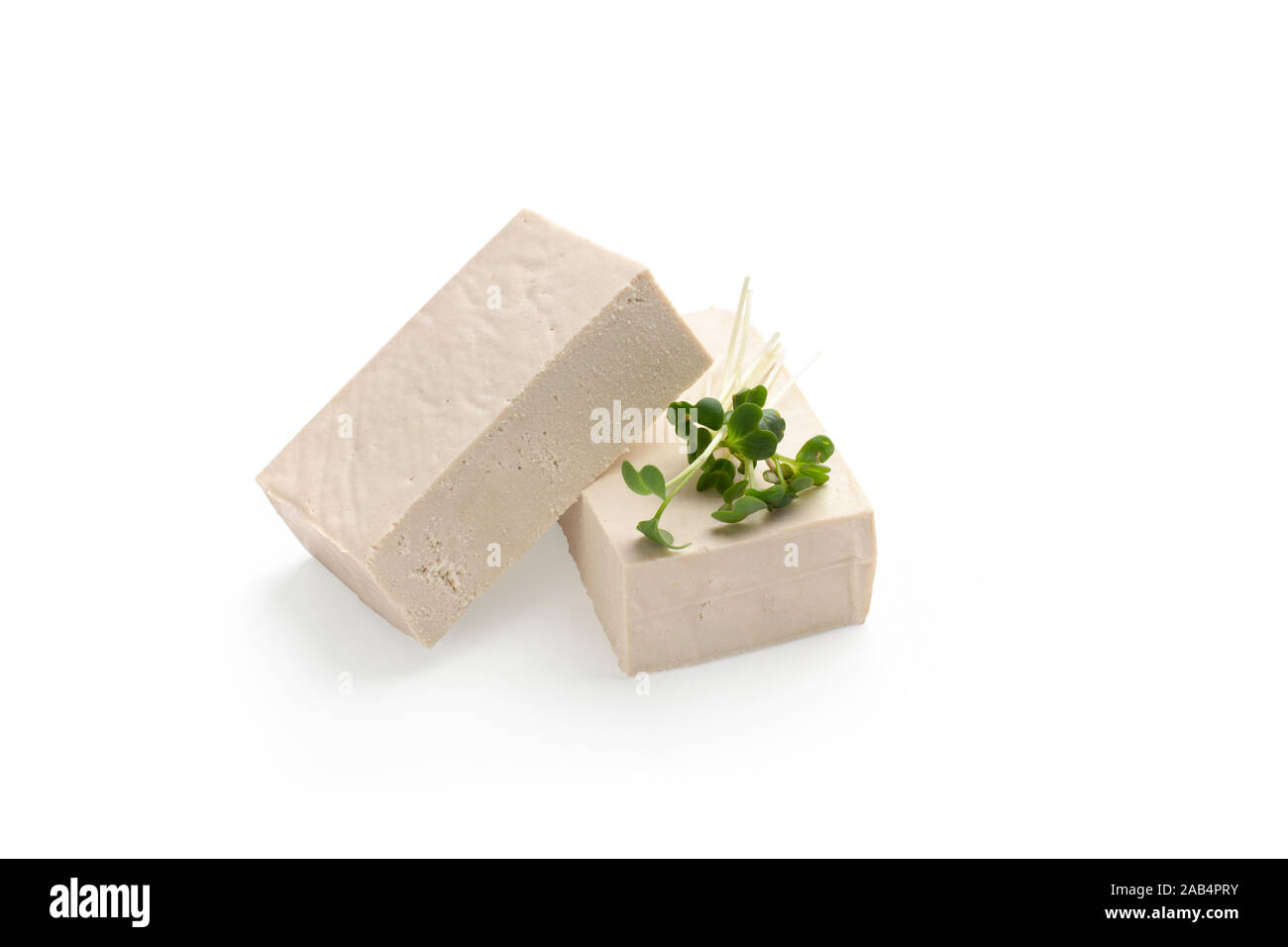 Blocchi di formaggio di tofu con foglie microgreen Foto Stock