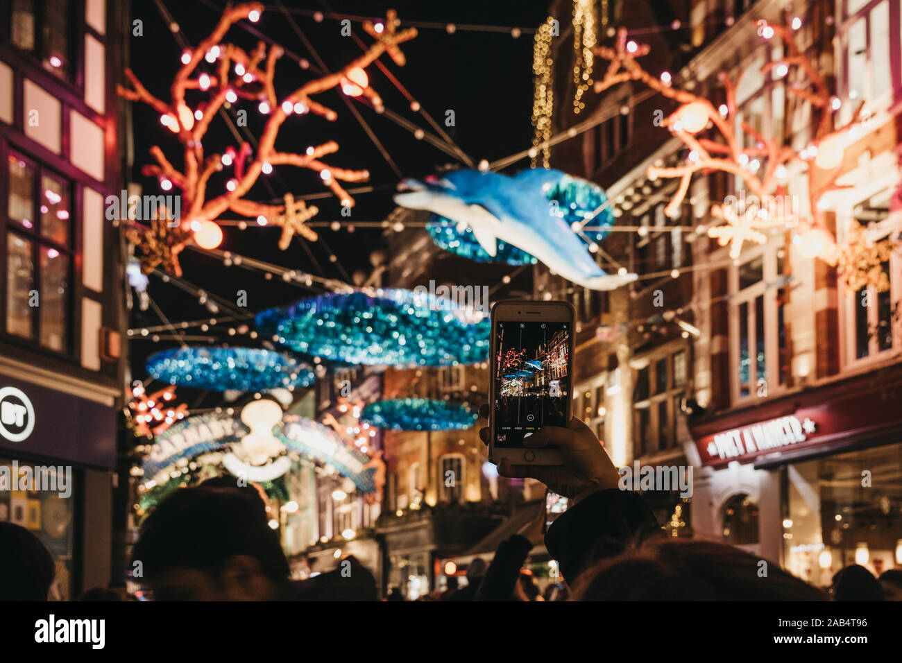 London, Regno Unito - 17 Novembre 2019: Donna di scattare le foto di Project Zero in tema di sostenibilità le luci di Natale in Carnaby Street, area pedonale per lo shopping Foto Stock