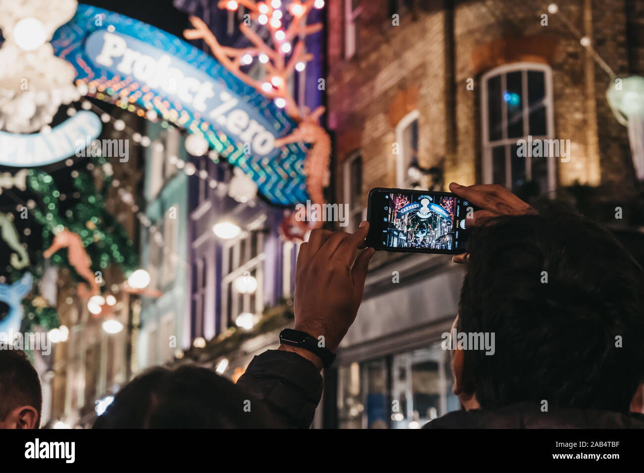 London, Regno Unito - 17 Novembre 2019: uomo di scattare le foto di Project Zero in tema di sostenibilità le luci di Natale in Carnaby Street, area pedonale per lo shopping st Foto Stock