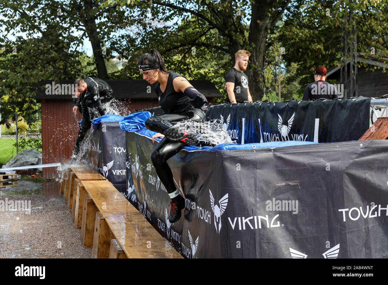 Sebbene Viking ostacolo corso i partecipanti gara salta fuori di acqua ghiacciata in piscina a Helsinki, Finlandia Foto Stock