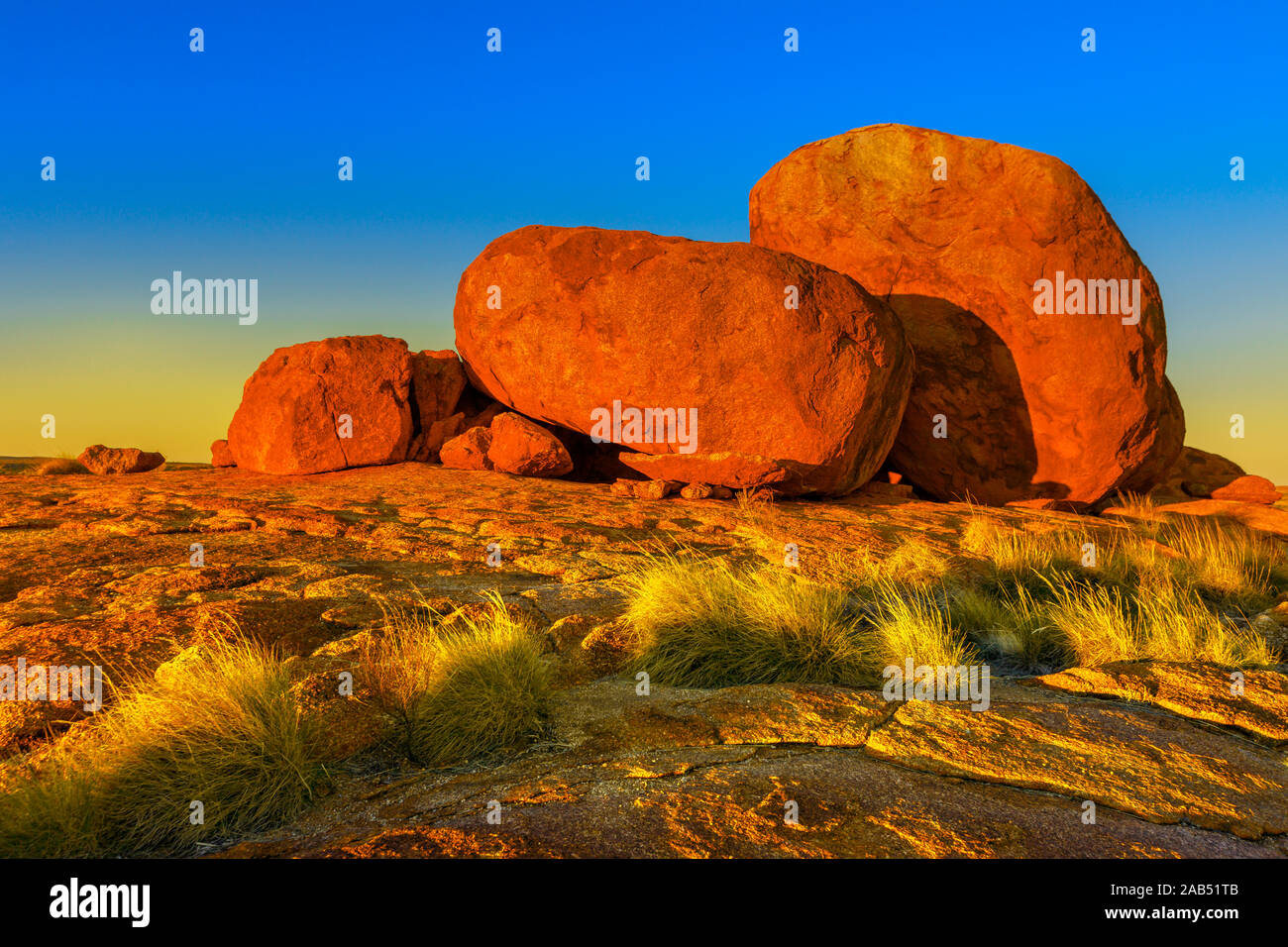 Stupendi paesaggi naturali whit colore rosso intenso al tramonto di diavoli marmi o Karlu Karlu. Massi ciclopici simbolo dell'Australia outback nel Nord Foto Stock