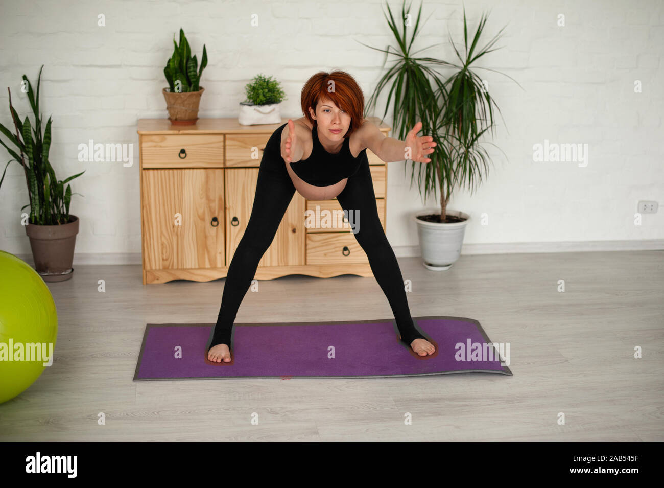 Ritratto di una giovane e bella donna incinta. Esercizi con fitball a casa. Lavoro fuori, yoga e fitness, il concetto di gravidanza. Foto Stock