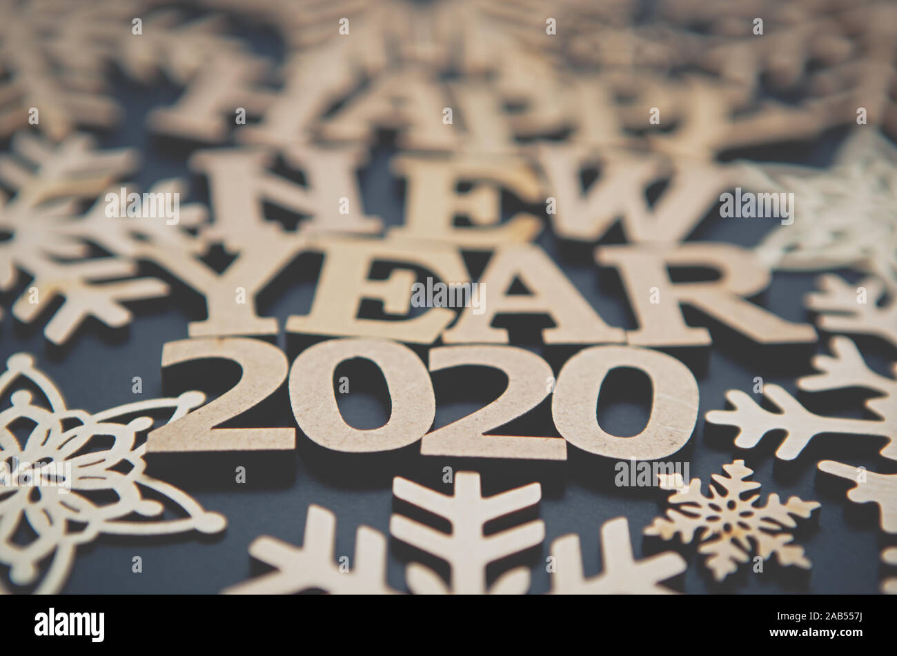 Felice Anno Nuovo 2020 sfondo.lettere in legno e i fiocchi di neve su sfondo scuro.vacanza invernale wallpaper con prodotti artigianali fatti a mano fatta da eco friendly mat Foto Stock