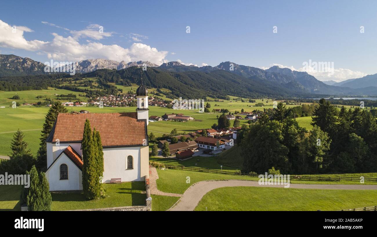 Cappella Sankt Peter, a Buching in Algovia, sullo sfondo da sinistra a destra il Hochplkatte, il Geiselstein, il Tegelberg, il Säuling, Swabi Foto Stock