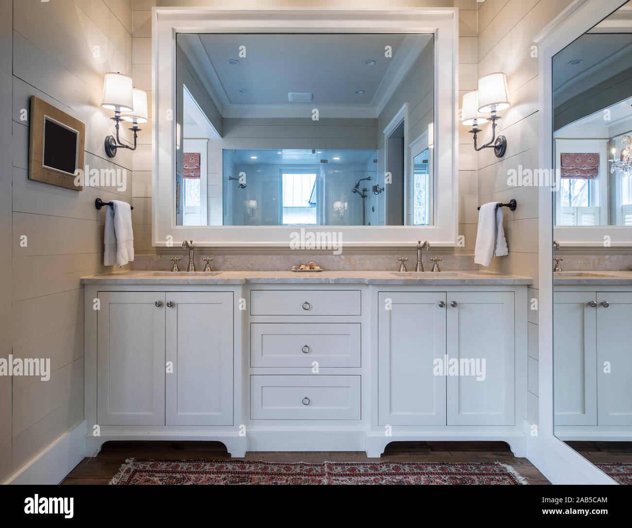 Bel bagno interno con doppi lavandini e bancone di marmo e grandi specchi. Foto Stock