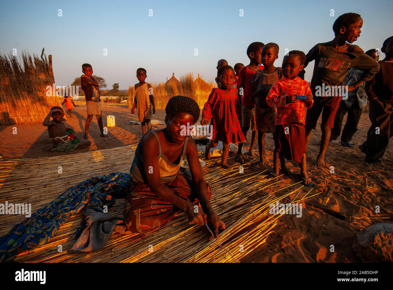 Abitanti di Caprivi Strip, donna costruendo un muro fatto di paglia a casa sua, Namibia Foto Stock