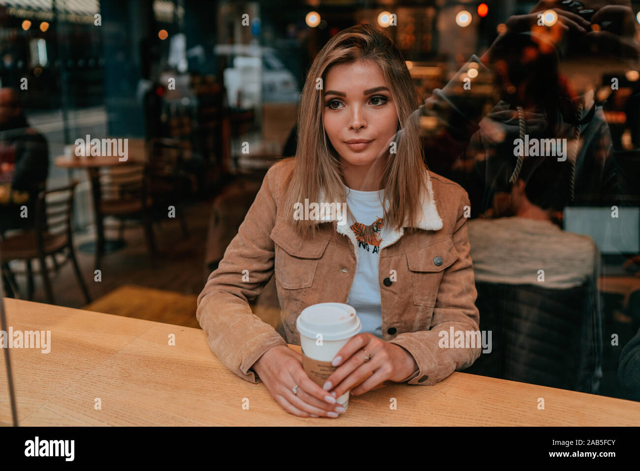 Affascinante Ritratto di giovane donna con capelli biondi, Street Style, ponendo in ambienti interni Foto Stock