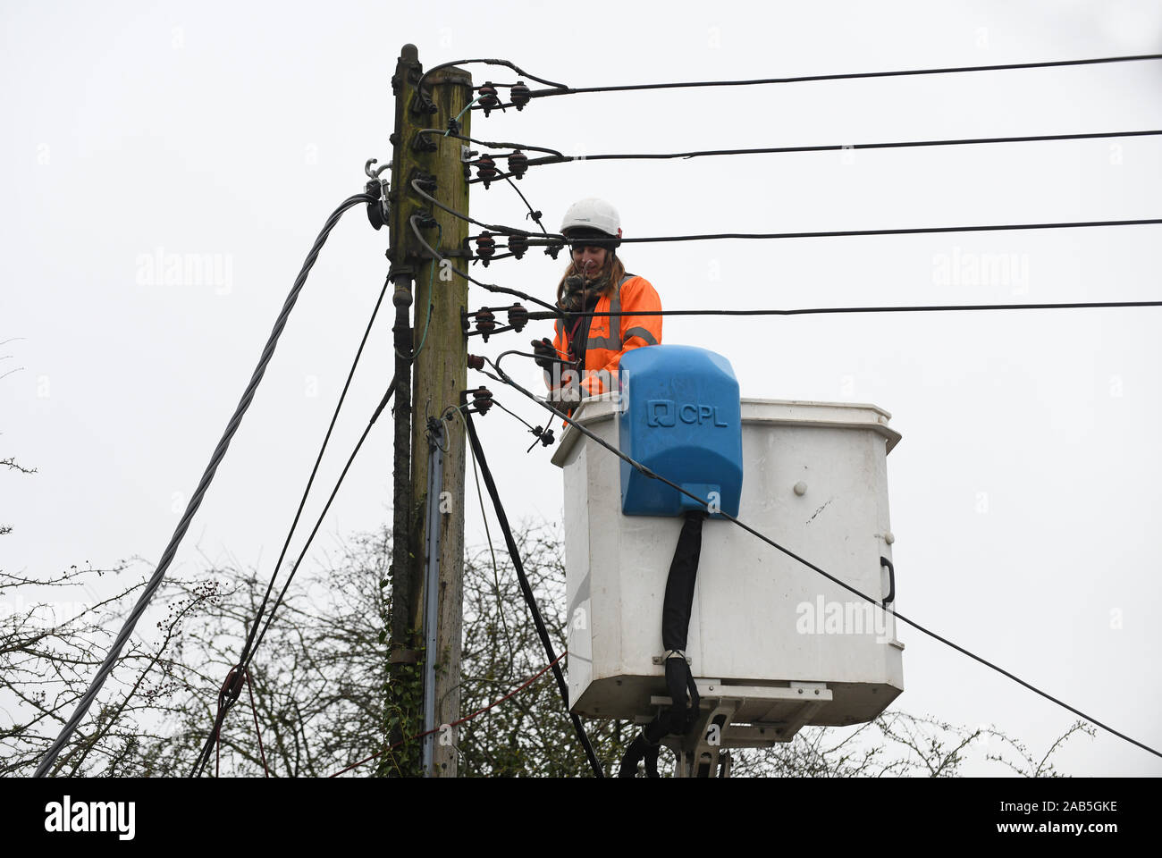 Elettricista in sostituzione di overhead di rete cavi di energia elettrica per la potenza occidentale distribuzione La rete di distribuzione di energia elettrica operatore Foto Stock