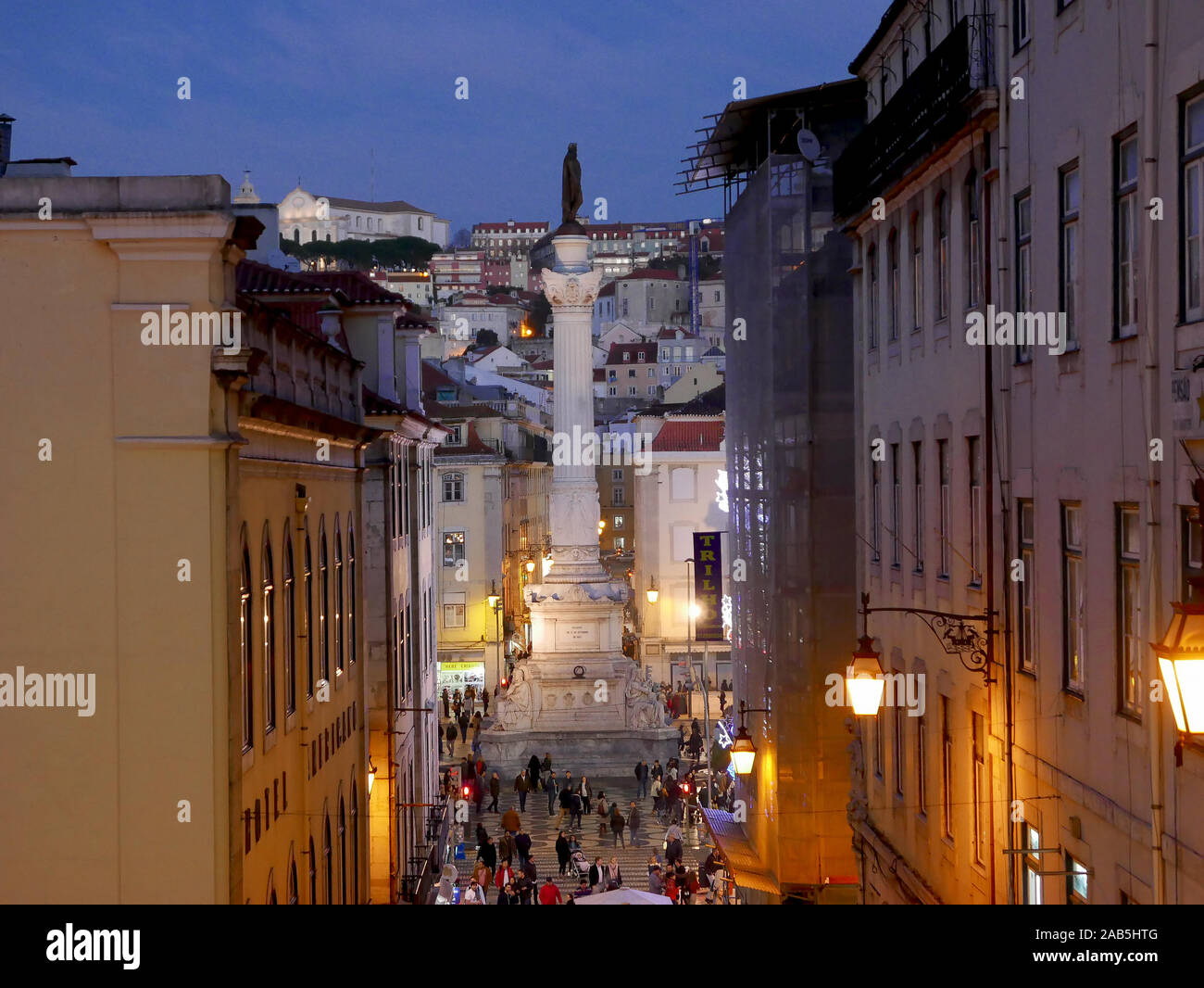 La colonna di Pedro IV nella piazza Rossio (Praca de D. Pedro IV) al crepuscolo in inverno guardando verso il basso dalla Calcada do Carmo Foto Stock