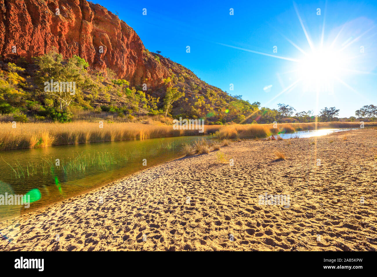 Glen Helen Gorge con Sunray e waterhole nel centro di outback australiano. West MacDonnell Ranges National Park rock formazione nel Territorio del Nord Foto Stock