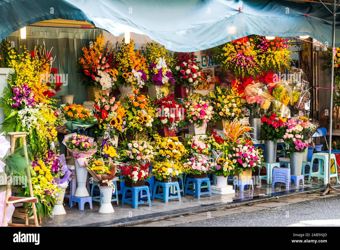 I grappoli di fiori luminosi in mazzi su display al di fuori di un negozio ad Hanoi, in Vietnam, in Asia Foto Stock