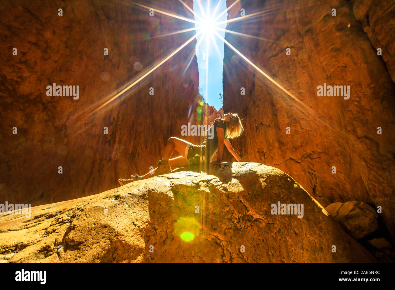 Lo stile di vita della donna a prendere il sole su una roccia all'interno del canyon di Standley Chasm, West MacDonnell Ranges. Australian Outback Red Centre, Territorio del Nord Foto Stock