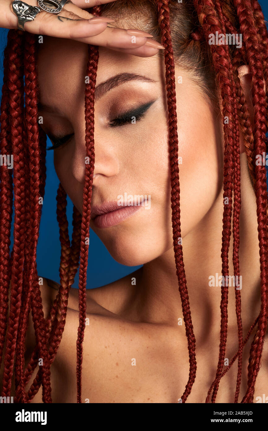 Immagine ravvicinata di una donna faccia con struttura ad albero rosso a treccia di capelli e la bellezza make up. Foto Stock