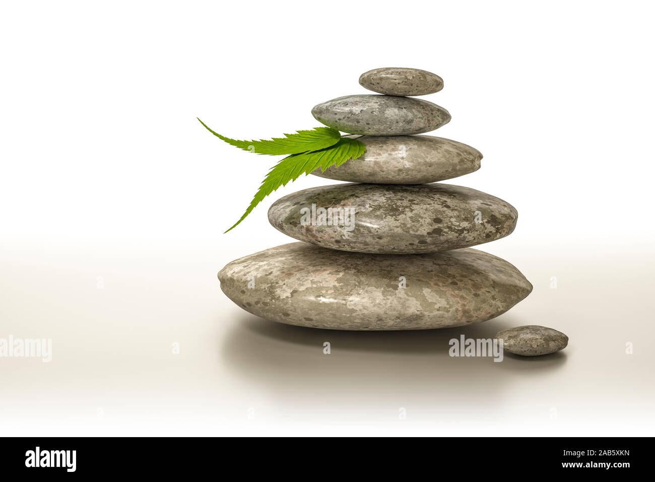 Ein Huegel aus Steinen und einem gruenen Blatt vor weissem Hintergrund Foto Stock