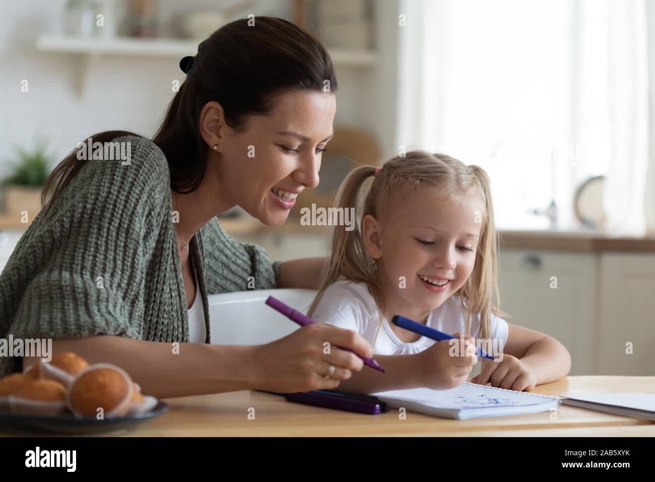 Babysitter insegnamento mom kid ragazza disegno con pennarello insieme Foto Stock