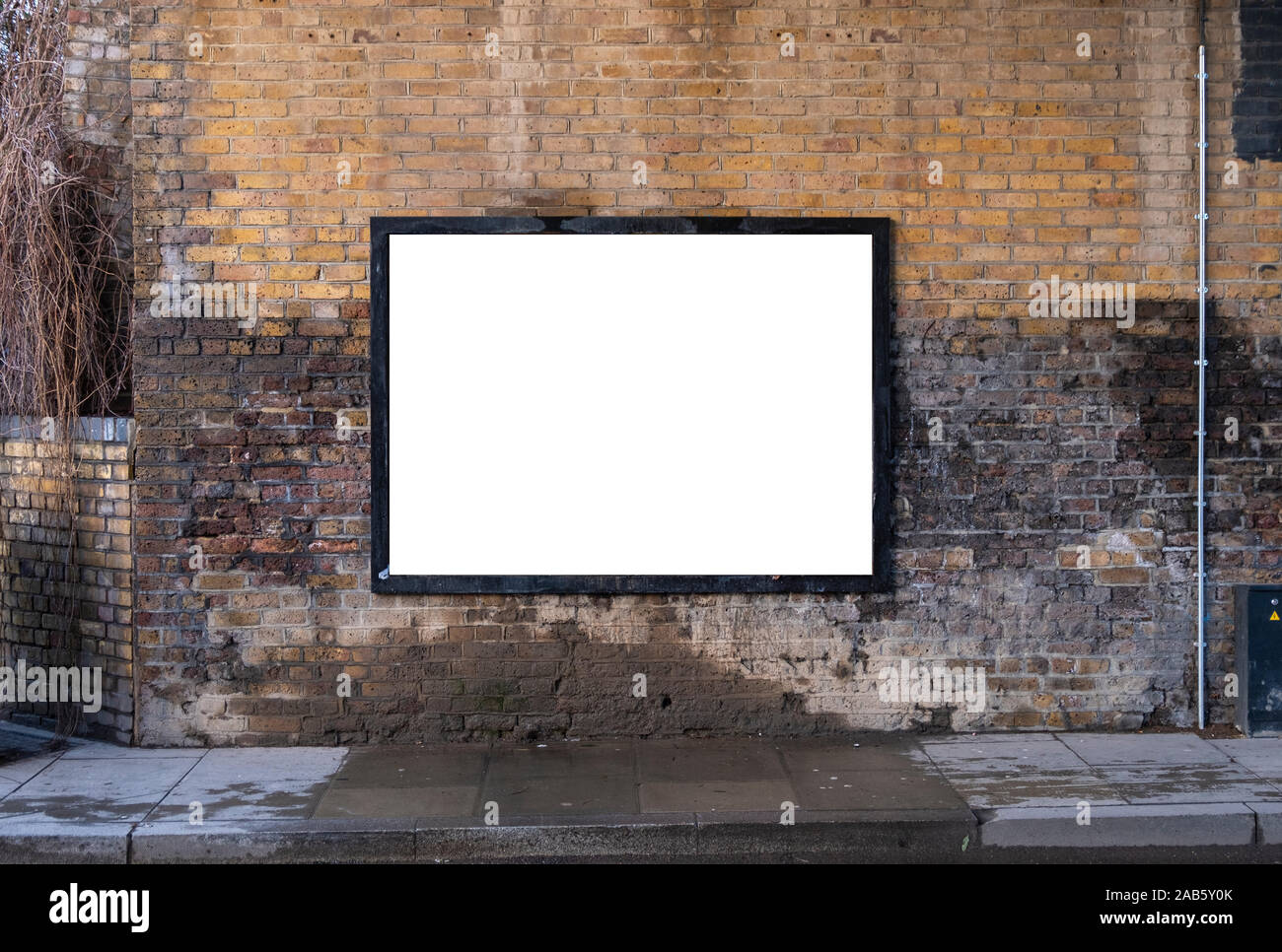 Affissioni vuota su un muro di mattoni vicino alla strada per pubblicità esterna poster artwork mockup Foto Stock