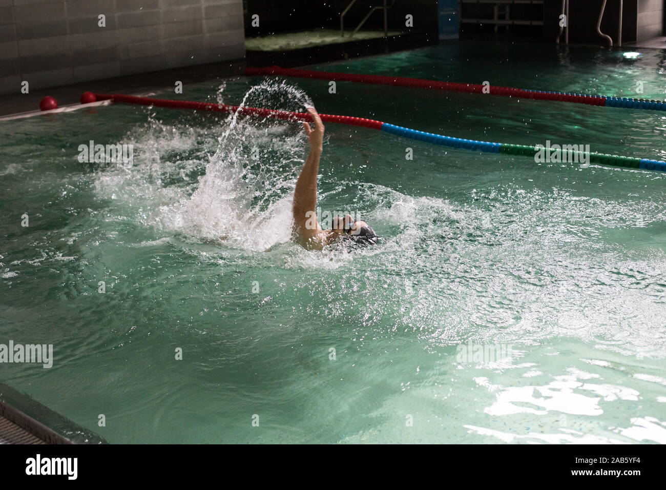 Uomo di nuoto in piscina coperta. Foto Stock