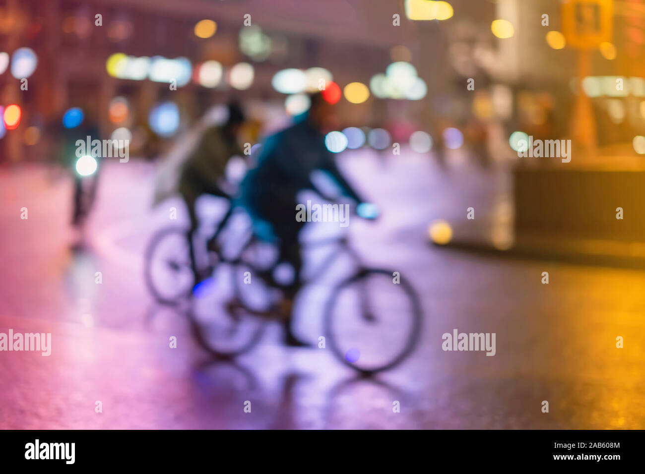 Abstract irriconoscibile la gente, equitazione biciclette, night city, illuminazione bokeh, motion blur. Uno stile di vita sano, attività di svago di concetto. Foto Stock