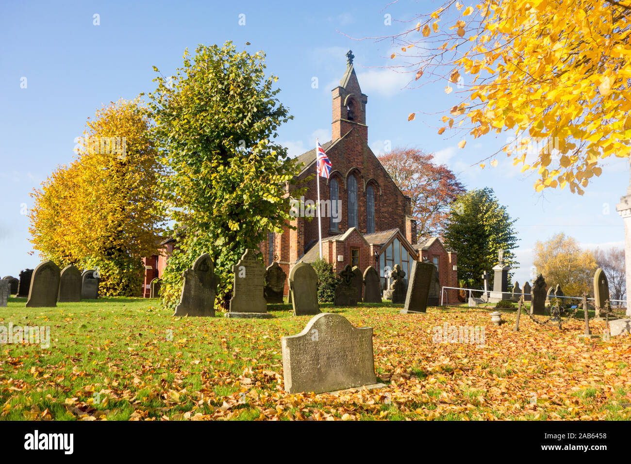 Chiesa parrocchiale La chiesa di Cristo e il suo cimitero con le lapidi nel Cheshire village di Wheelock durante l'autunno Foto Stock