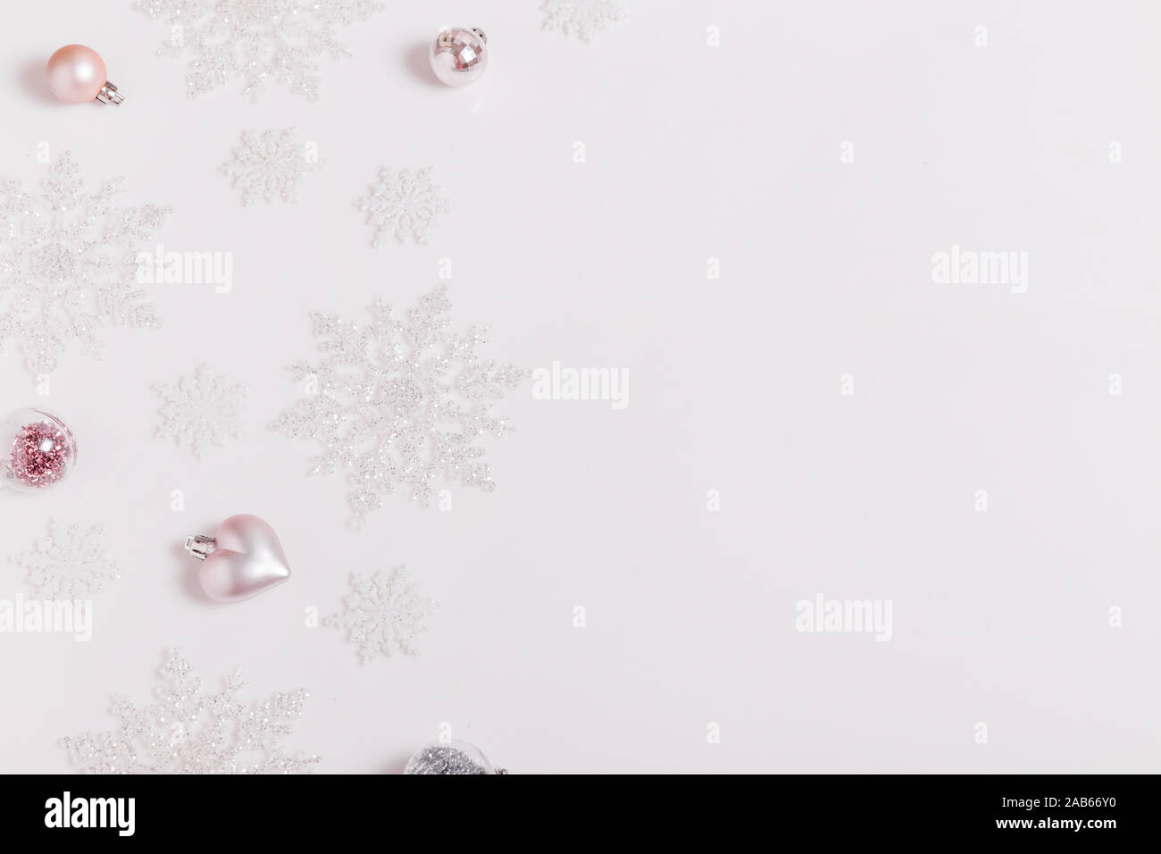 Composizione di natale. Cornice fatta di palline e fiocchi di neve pastello su sfondo grigio. Foto Stock