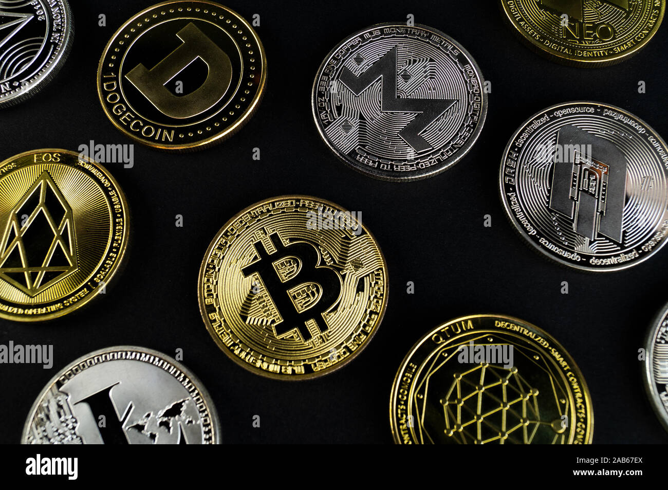 Un sacco di monete cryptocurrency giacciono su di una superficie scura sullo sfondo Foto Stock