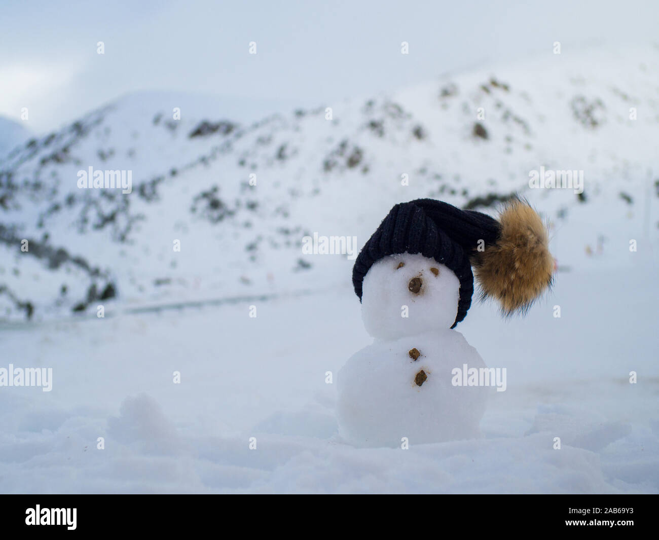 Poco pupazzo di neve in natura in presenza di neve e freddo giorno di montagne Foto Stock