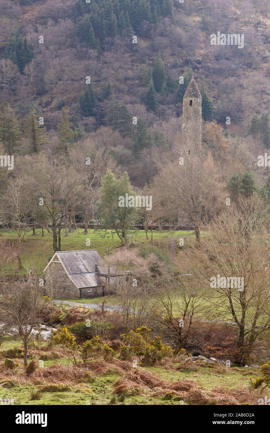 La torre circolare e la casa parrocchiale a Glendalough Irlanda Foto Stock