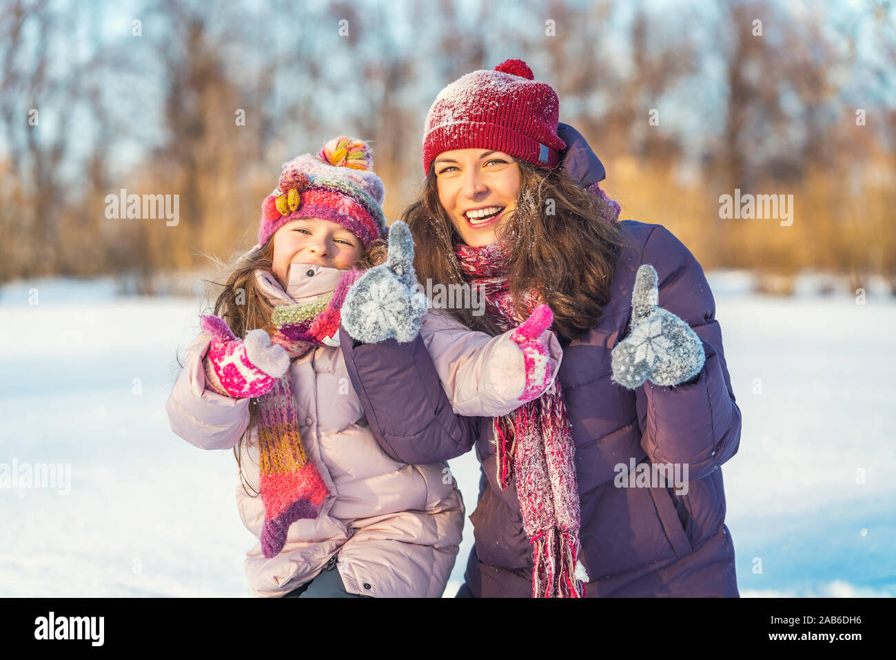 Positivo madre e figlia giocando in winter park Foto Stock