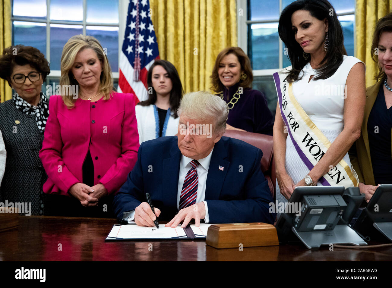 Il presidente statunitense Trump (C) segni " il suffragio femminile Centennial una moneta commemorativa atto", accanto al fianco degli Stati Uniti il senatore Marsha Blackburn (Repubblicano del Tennessee) (L), nell'Ufficio Ovale della Casa Bianca di Washington, DC, Stati Uniti d'America, 25 novembre 2019. Trump firmato "H.R. 2423, il suffragio femminile Centennial una moneta commemorativa atto " - un disegno di legge dirigere il Tesoro USA alla menta e rilascio fino al quattrocento mila one-dollar monete d'argento per onorare le donne che hanno giocato un ruolo nella raccolta di supporto per il XIX emendamento.Credit: Michael Reynolds/Piscina via CNP | Utilizzo di tutto il mondo Foto Stock
