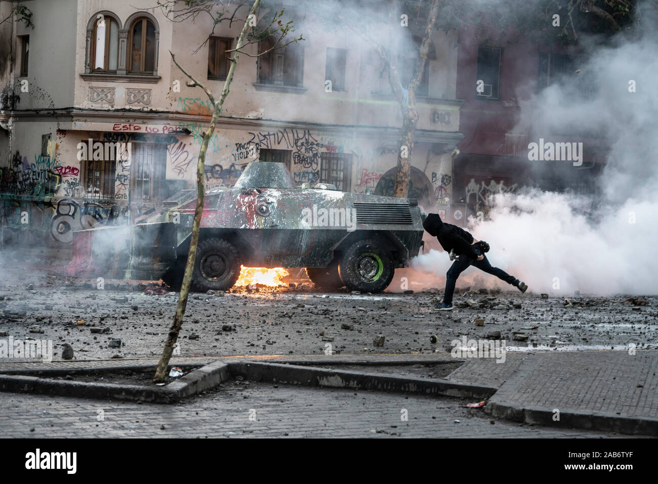 Protesta che lancia la bomba molotov al carro armato della polizia durante gli scontri tra la polizia e i manifestanti a Vicuña Mackenna durante gli ultimi scontri a Santiago Foto Stock