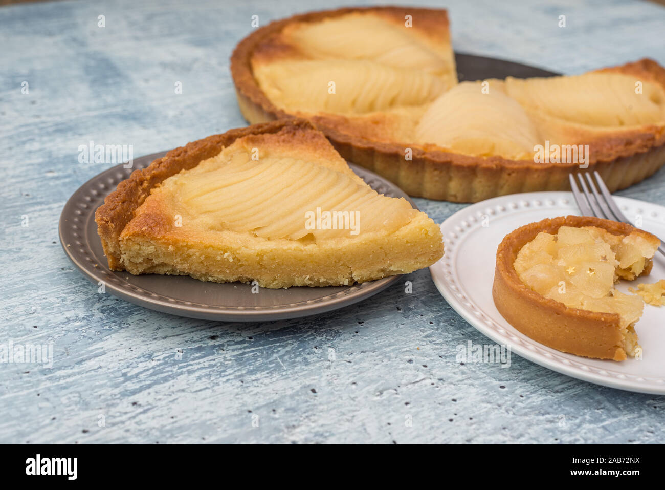 Una deliziosa casa cuocere pera affogata tart pie, come noto come Tarte Bourdaloue, una tazza di caffè latte. Si tratta di un popolare francese ricetta che prende il nome dal Foto Stock