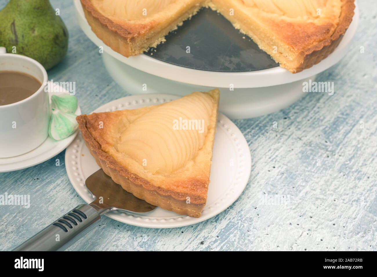 Una deliziosa casa cuocere pera affogata tart pie, come noto come Tarte Bourdaloue, una tazza di caffè latte. Si tratta di un popolare francese ricetta che prende il nome dal Foto Stock