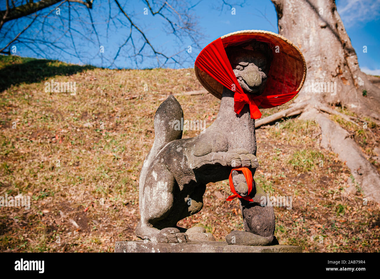 Kitsune Fox giapponese statua di pietra con red scarft e hat al santuario di Aizu Wakamatsu Tsuruga Castle - Close up viso dettagli - Giappone dio guard fox Foto Stock