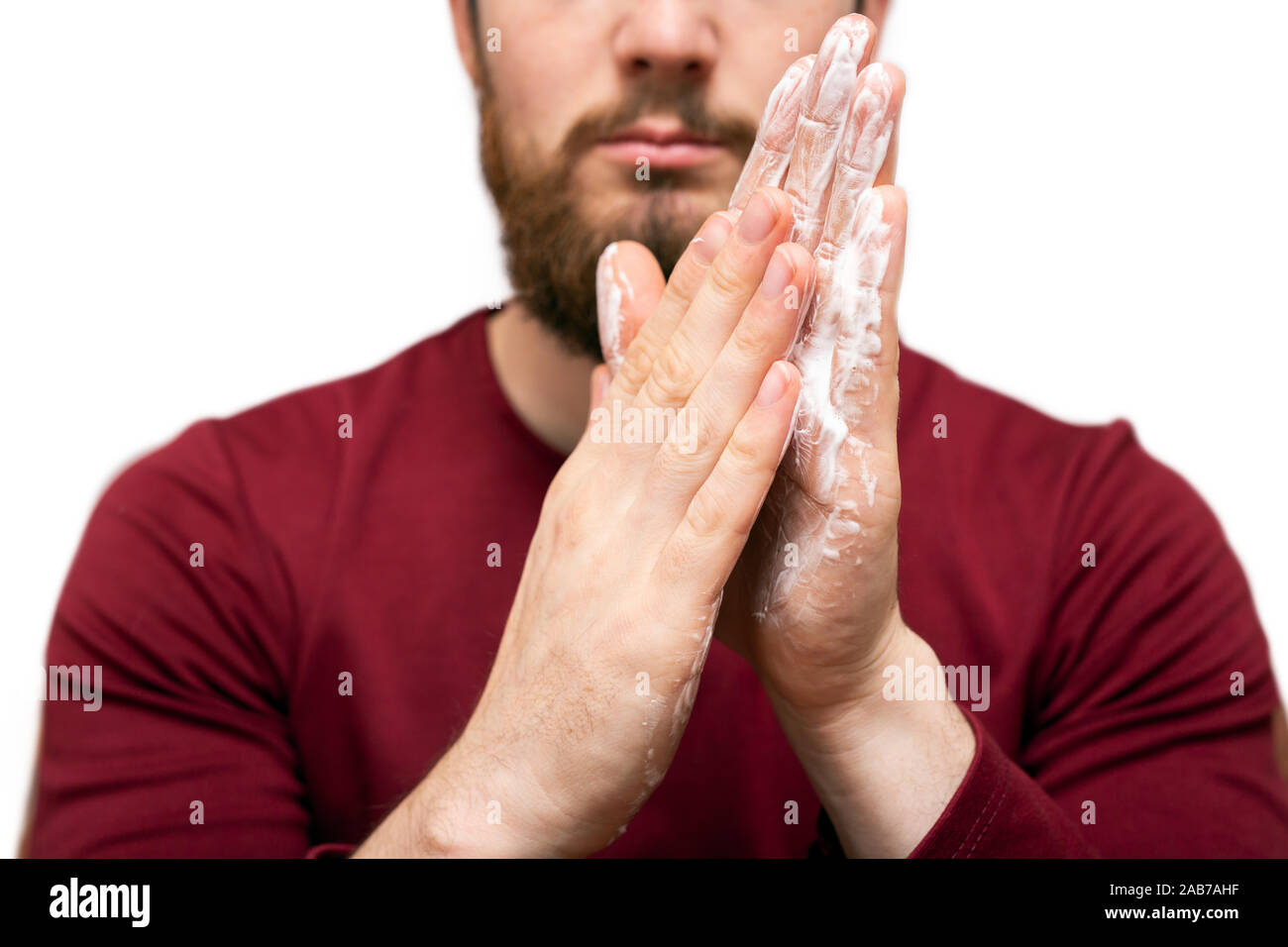 Salute bellezza e cura della pelle concetto. Closeup giovane uomo barbuto con la barba sapone o shampoo sulla sua mano per il lavaggio di barba, concetto di pulizia Foto Stock