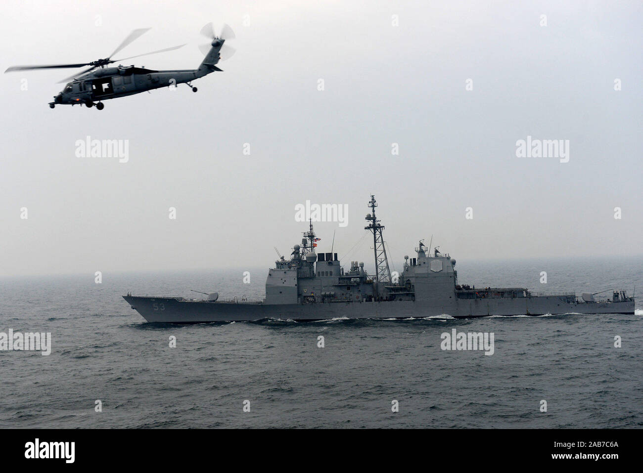 (Gen. 29, 2013) un MH-60S Sea Hawk elicottero dall'Eightballers di elicottero di mare squadrone di combattimento (HSC) 8 mosche da Ticonderoga-class guidato-missili cruiser USS Mobile Bay (CG 53) durante un rifornimento in mare. Mobile Bay, assegnato a John C. Stennis Carrier Strike gruppo, è distribuito negli Stati Uniti Quinta Flotta area di responsabilità condurre le operazioni di sicurezza marittima, teatro la cooperazione in materia di sicurezza gli sforzi e le missioni di sostegno per l'Operazione Enduring Freedom. Foto Stock