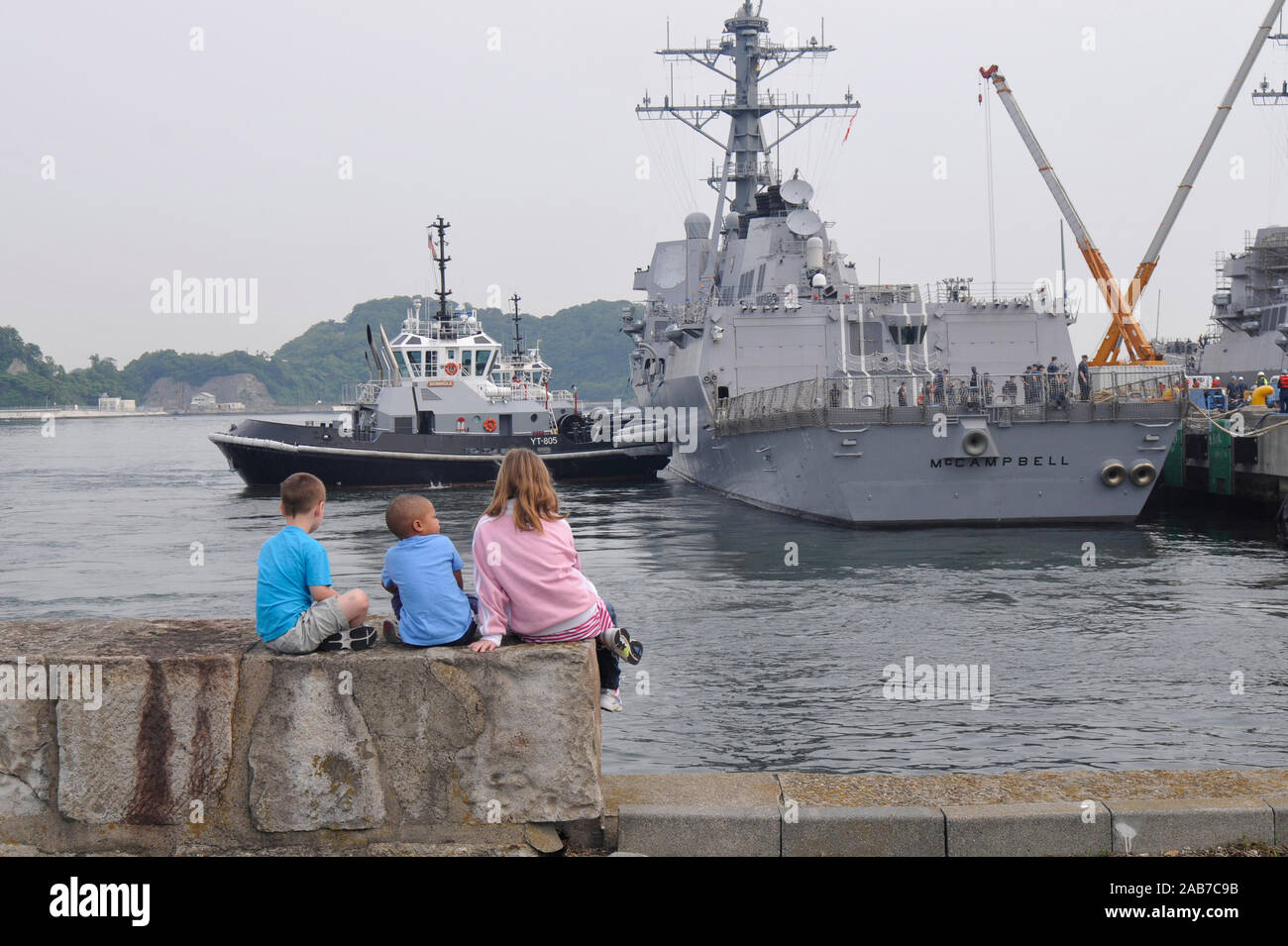 YOKOSUKA, Giappone (17 maggio 2012) i bambini di velisti assegnati alle visite-missile destroyer USS McCampbell (DDG 85) guarda il come la nave parte per una pattuglia del Pacifico occidentale. Foto Stock